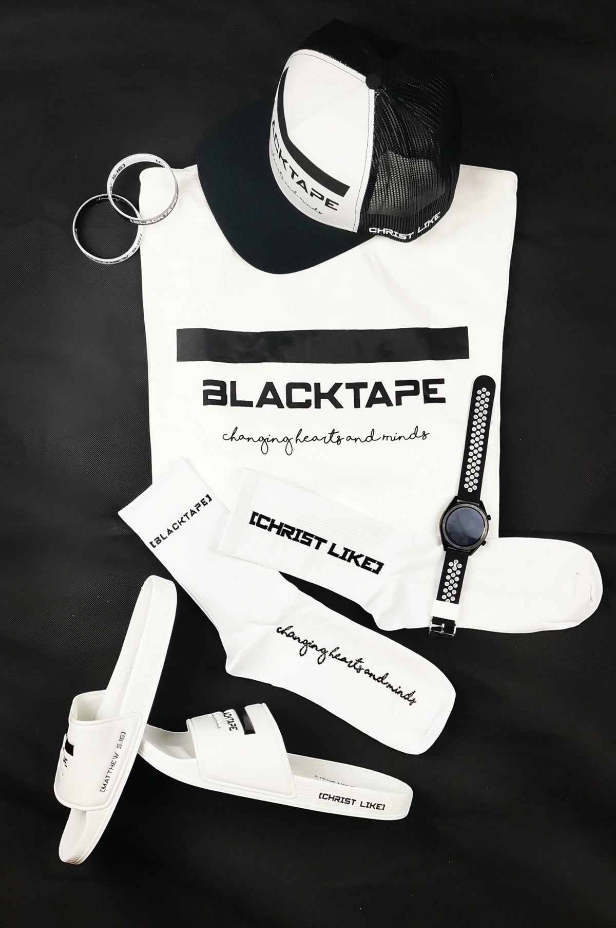 Blacktapechamchristlike branded white t-shirt, cap, socks, and slides with black text and matching accessories.