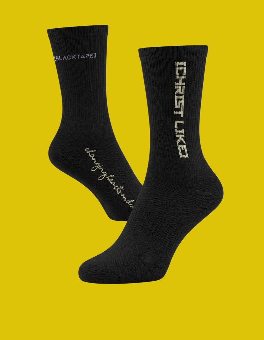 Blacktapechamchristlike Night Sun crew socks in black cotton with white embroidered Christ Like text on yellow background