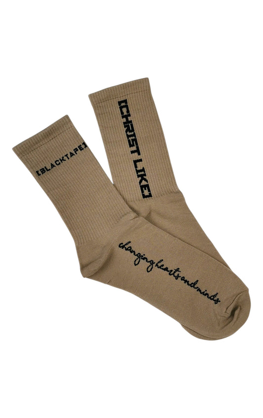 Blacktapechamchristlike Potter's Clay crew socks in tan cotton with black embroidered Christ Like text and branding.