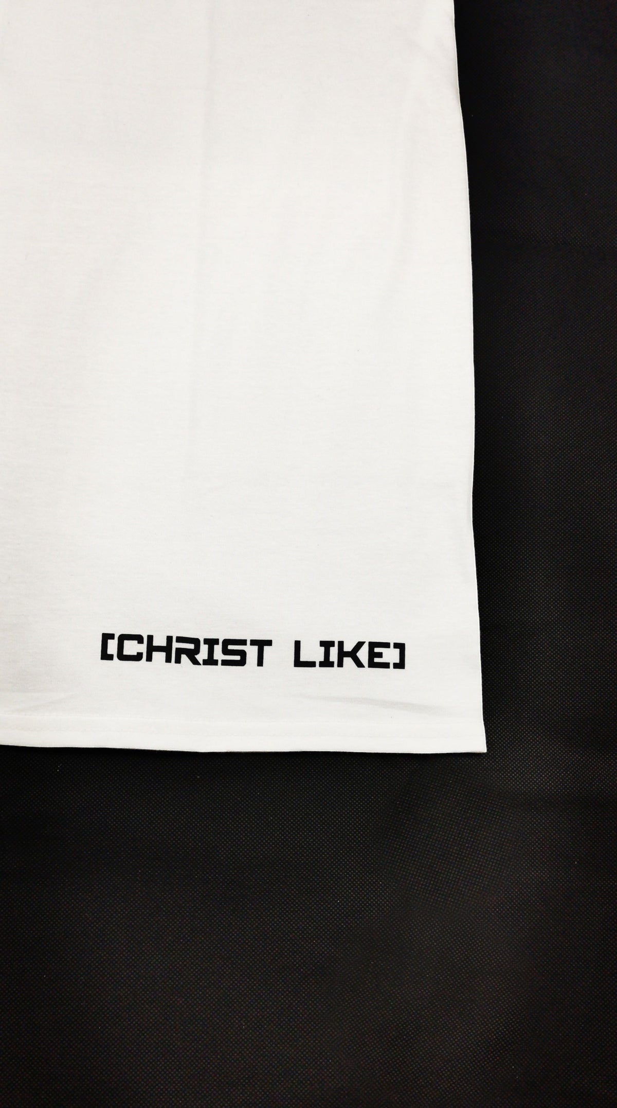 Blacktapechamchristlike white cotton crew tee featuring Christ Like screen-printed text on the bottom hem